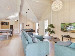 A modern living room with a pool table, a sofa set, a television, and a large window with a view of a waterfall. - 5 Star Holiday Home in Frederiksvaerk (Frederiksvaerk)