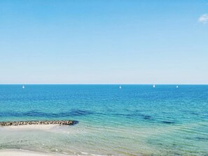 A clear view of the ocean with a rocky shoreline and sailboats in the distance. - 5 Star Holiday Home in Frederiksvaerk (Frederiksvaerk)