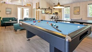 A pool table with balls, a sofa, and a ping pong table in a room with wooden walls and ceiling. - 5 Star Holiday Home in Frederiksvaerk (Frederiksvaerk)