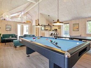 A pool table with balls, a sofa, and a ping pong table in a room with wooden walls and ceiling. - 5 Star Holiday Home in Frederiksvaerk (Frederiksvaerk)