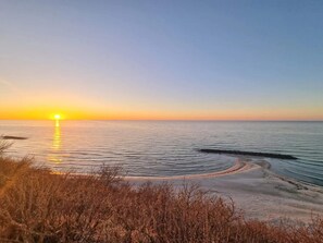A beach with a sunset, calm sea, and sandy shore. - 5 Star Holiday Home in Frederiksvaerk (Frederiksvaerk)