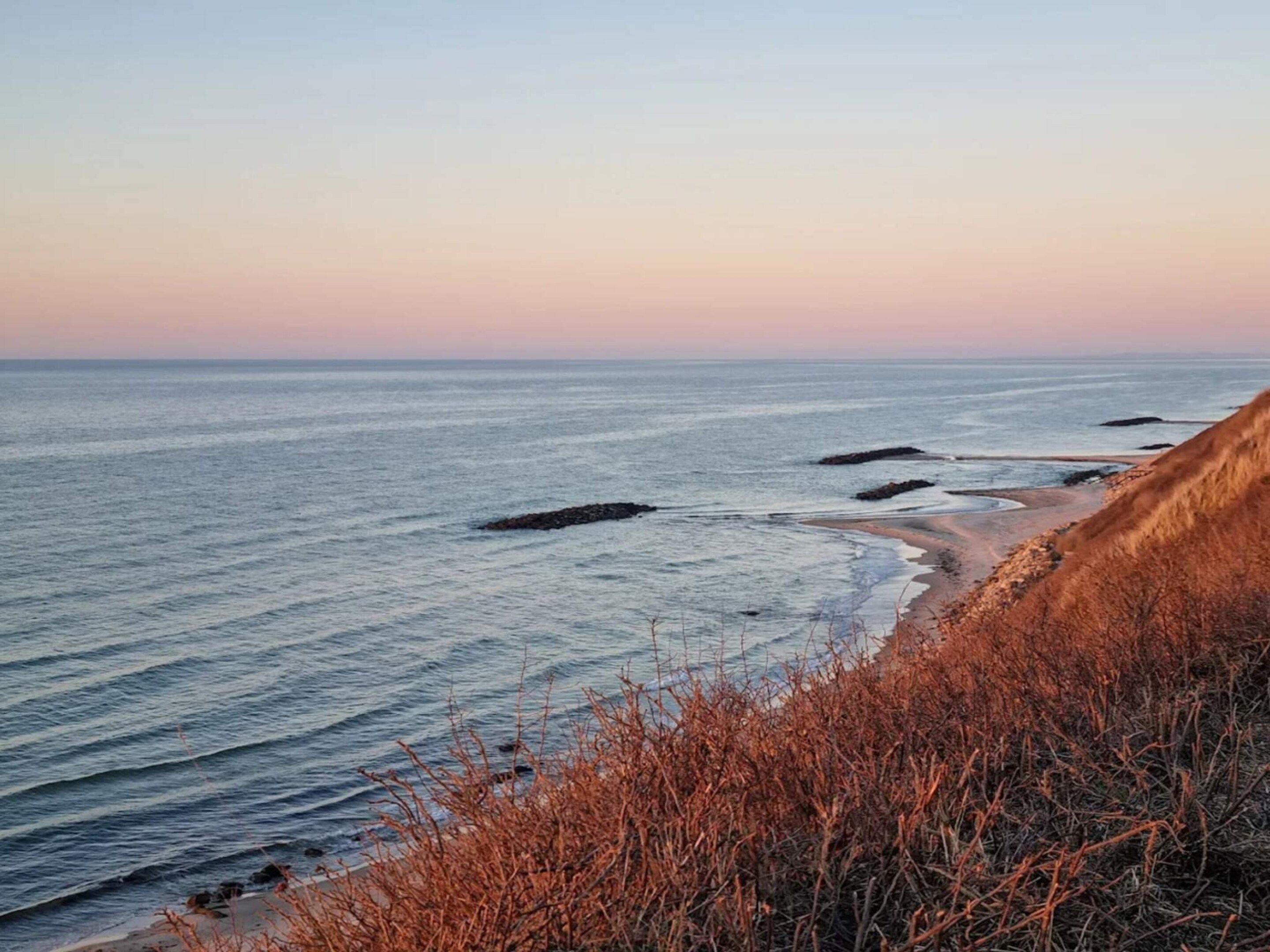 Eine Küstenlandschaft mit Strand, Meer und Felsen.