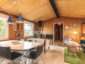 A cozy cabin interior with a dining area, a living room, and a fireplace. - 6 Person Holiday Home in Thisted (Thisted)