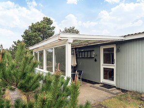 A single-story building with a covered patio area, large windows, and a door leading to the interior. - 6 Person Holiday Home in Thisted (Thisted)