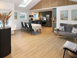 Relax in this spacious living area with a dining table, sofa, and side table, offering a view of the outdoors.