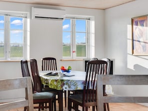 Un coin repas avec une table ronde, des chaises et une fenêtre donnant sur l’extérieur.