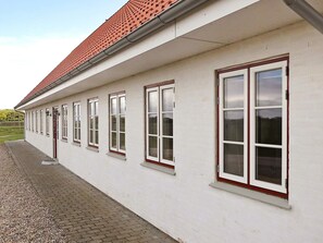 A building with a series of windows and a red-tiled roof.