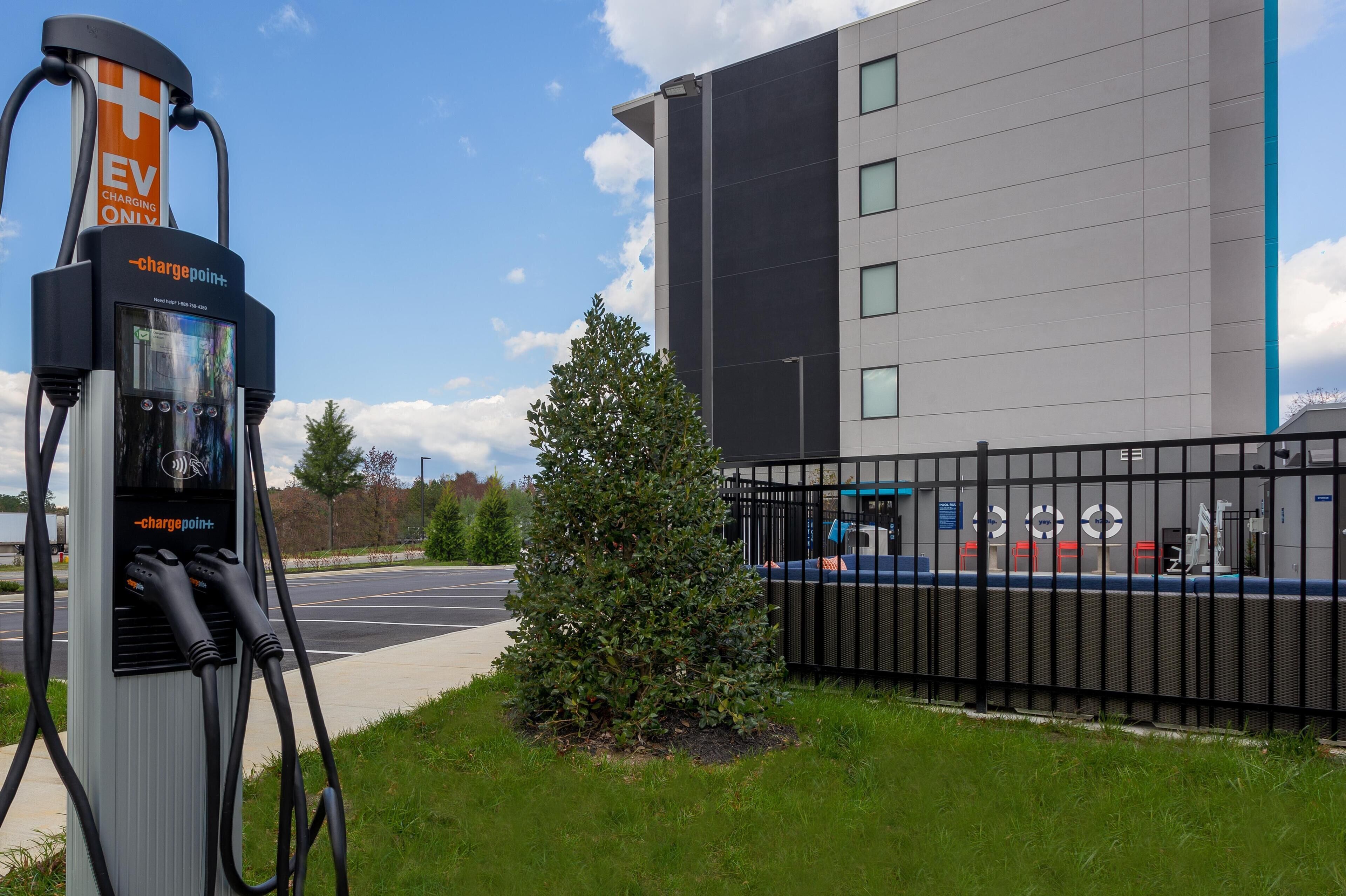 An EV charging station with a modern building in the background.