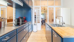 Una cocina moderna con armarios azul oscuro, encimera de madera y una isla central.