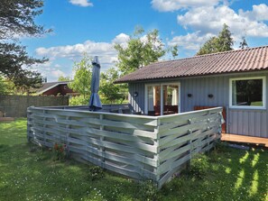 A wooden deck with a covered seating area and a small building with a tiled roof. - 6 Person Holiday Home in Gedser-by Traum (Gedser)