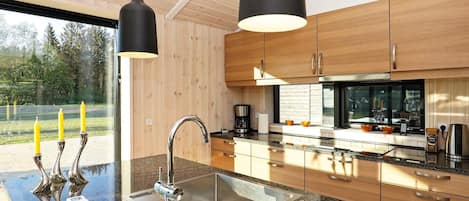 A modern kitchen with granite countertops, stainless steel appliances, and wooden cabinetry.