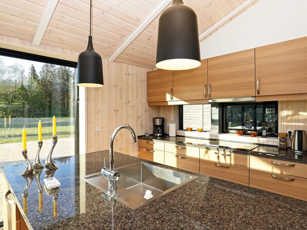 A modern kitchen with granite countertops, stainless steel appliances, and wooden cabinetry.