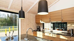A modern kitchen with granite countertops, stainless steel appliances, and wooden cabinetry. - 5 Star Holiday Home in Hjorring (Hjørring)