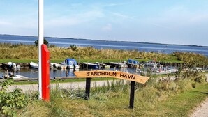 A signpost with 'SANDHOLM HAVN' written on it, indicating a location near a body of water with boats docked. - 4 Person Holiday Home in Ulfborg-by Traum (Ulfborg)