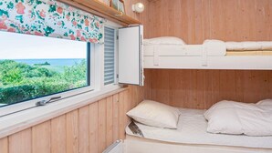 A bunk bed room with a window overlooking greenery and a view of the sea. - Fantastic Holiday Home in Knebel With Wifi (Knebel)
