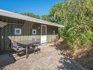 A wooden building with a metal table and chairs outside, a door, and a window. - Fantastic Holiday Home in Knebel With Wifi (Knebel)