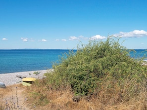 A beach with a clear view of the sea, a rocky shoreline, and some vegetation. - Fantastic Holiday Home in Knebel With Wifi (Knebel)