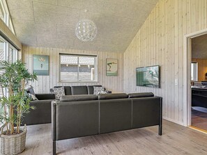 Un salon avec un canapé, une grande fenêtre et une plante en pot.
