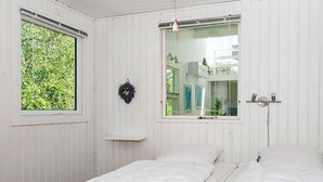 A white room with a bed, a window, a mirror, and a shelf. - Simplistic Holiday Home in Ringkøbing near Sea (Ringkobing)