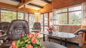 A cozy room with a leather sofa, a leather armchair, and a table with a vase of flowers. - Fantastic Holiday Home with Sauna near Roslev (Roslev)