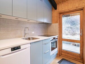 A modern kitchen with a dishwasher, sink, and built-in oven. - 6 Person Holiday Home in Skagen (Skagen)