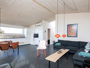 A modern living space with a kitchen, dining area, and a sofa.
