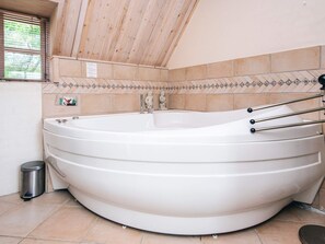 A large, freestanding bathtub in a room with wooden ceiling beams and tiled walls. - 5 Person Holiday Home in Ringkobing-by Traum (Ringkobing)