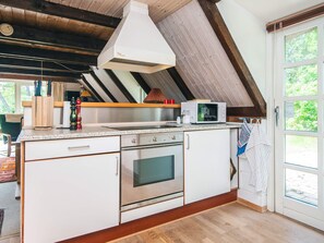 A kitchen with a built-in oven, microwave, and a large window. - 5 Person Holiday Home in Ringkobing-by Traum (Ringkobing)