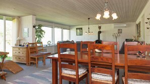 Amplia habitación con una mesa de comedor de madera, sillas y un gran ventanal que ofrece luz natural.