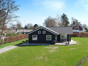 A black house with a tiled roof, a number '67' on the side, and a small patio area. - 10 Person Holiday Home in Hadsund-by Traum (Hadsund)