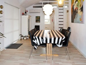 A dining area with a striped tablecloth, black chairs, and a hanging light fixture. - 10 Person Holiday Home in Hadsund-by Traum (Hadsund)