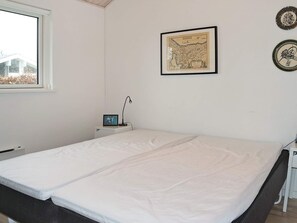 A room with a bed, a desk with a lamp, a framed map on the wall, and a window. - 10 Person Holiday Home in Hadsund-by Traum (Hadsund)