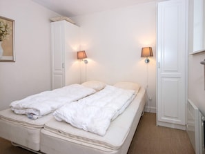 A twin bed with two pillows, a white wardrobe, and two wall-mounted lamps. - 8 Person Holiday Home in Gjern-by Traum (Gjern)