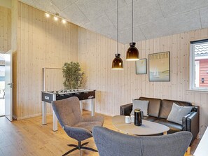 A cozy room with a foosball table, a sofa, and a coffee table. - 5 Star Holiday Home in Grenaa (Grenaa)