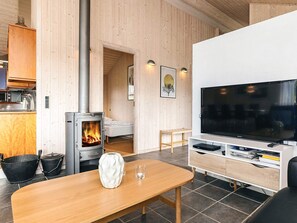 Una habitación acogedora con chimenea, televisor y zona de comedor.