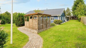A house with a covered porch, a paved pathway, and a grassy yard. - 9 Person Holiday Home in Jaegerspris-by Traum (Jægerspris)