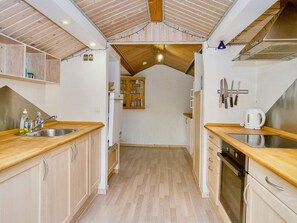 A kitchen with wooden cabinets, a stainless steel sink, and a built-in oven. - 9 Person Holiday Home in Jaegerspris-by Traum (Jægerspris)