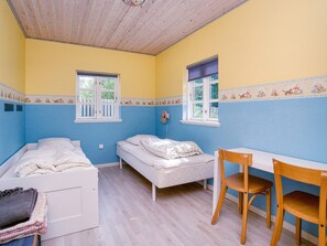 A room with two beds, a table, and a chair. - 9 Person Holiday Home in Jaegerspris-by Traum (Jægerspris)