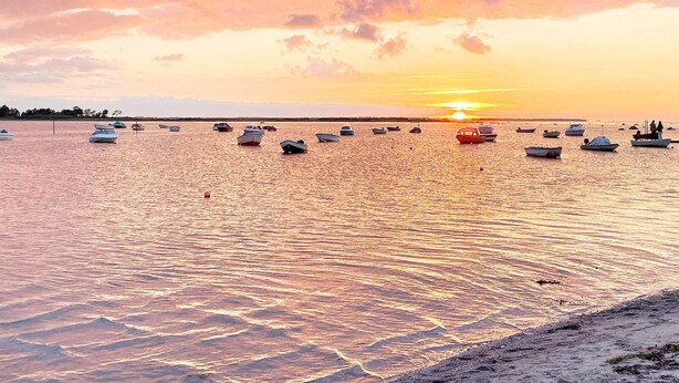 A sunset over a calm sea with several boats anchored. - 9 Person Holiday Home in Jaegerspris-by Traum (Jægerspris)