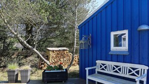 A blue building with a white bench and a small table with plants. - Secluded Beach Retreat - By Traum Ferienwohnungen (Skagen)