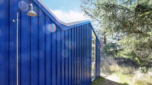 A blue building with a shower area, a window, and a door. - Secluded Beach Retreat - By Traum Ferienwohnungen (Skagen)