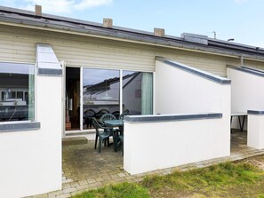 A single-story building with a patio area featuring a table and chairs. - 6 Person Holiday Home in Brovst-by Traum (Brovst)