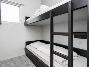 A bunk bed with white bedding in a room with white walls and a window. - 6 Person Holiday Home in Brovst-by Traum (Brovst)