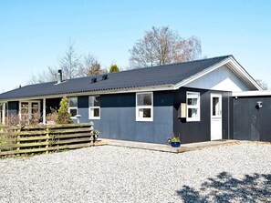 A single-story building with a dark exterior, a sloped roof, and a small porch area. - 4 Star Holiday Home in Odder (Odder)