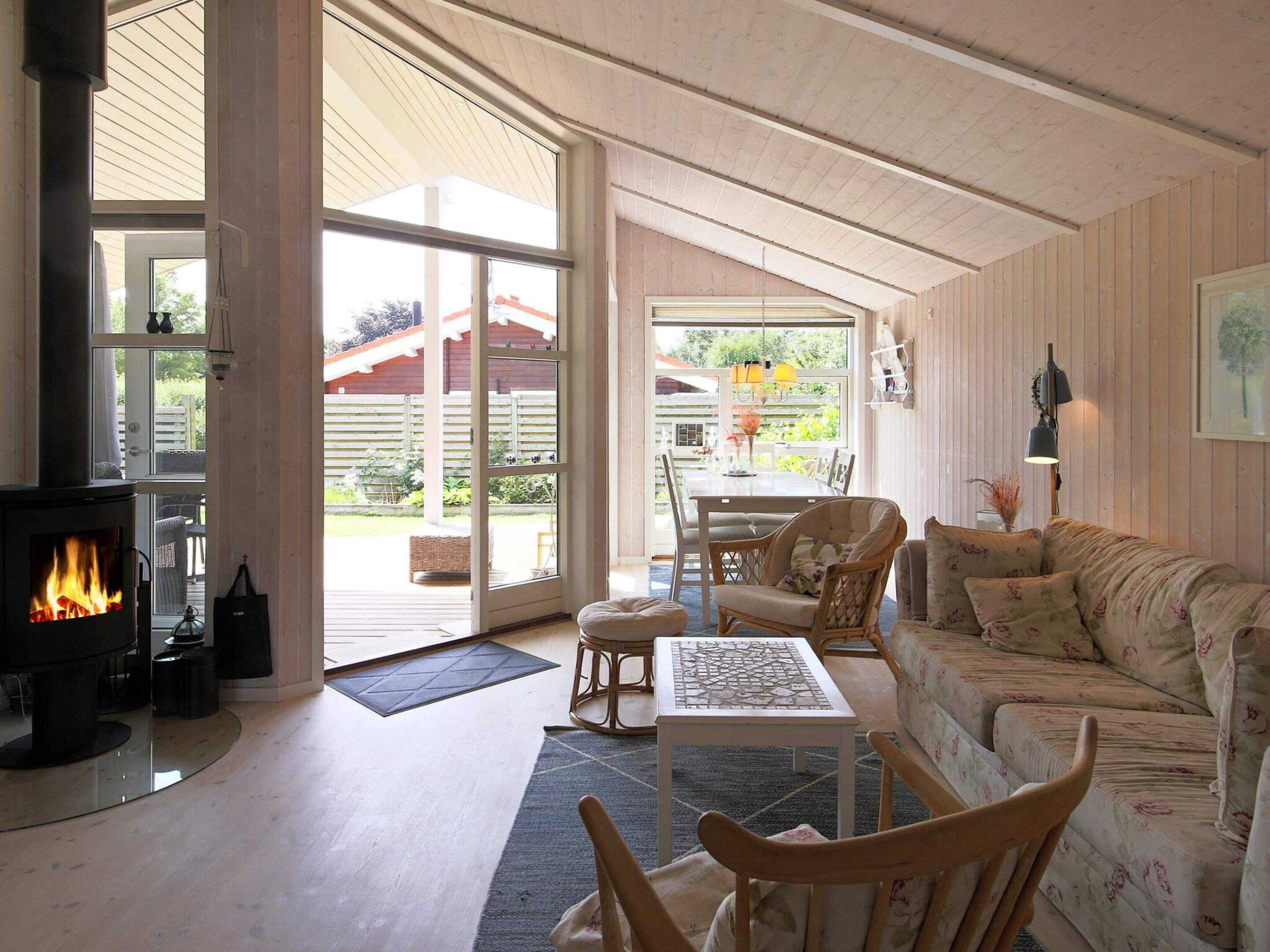 A cozy living room with a fireplace, a dining area, and a large sliding glass door leading to an outdoor space.