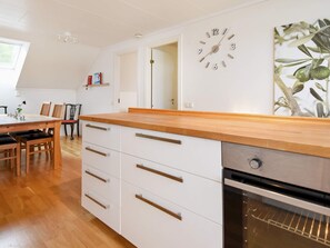A modern kitchen with wooden countertops, white cabinetry, and an oven. - 6 Person Holiday Home in Kode (Kode)