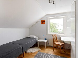 A small, tidy room with a bed, a desk, a chair, and a window. - 6 Person Holiday Home in Kode (Kode)