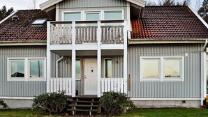 A two-story building with a balcony, large windows, and a front door. - 6 Person Holiday Home in Kode (Kode)