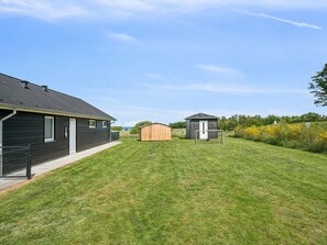 Ein Wohnhaus mit Gartenhaus und umzäunter Grundstück.