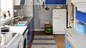 A compact kitchen with a stove, sink, and a small refrigerator. - 6 Person Holiday Home in Arjang (Årjäng)
